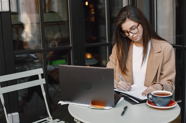 Femme travaillant sur un ordinateur portable dans un café de la rue