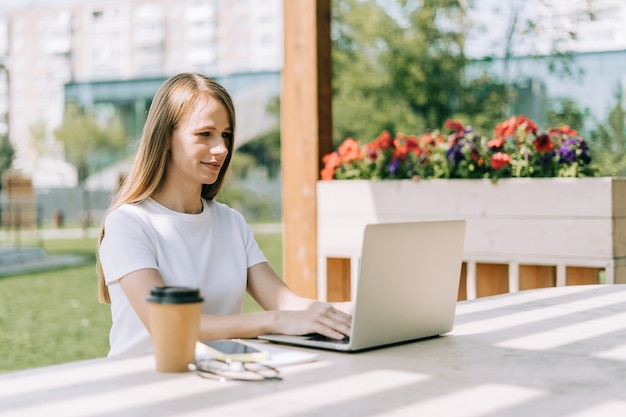 Femme travaillant sur un ordinateur portable à l'extérieur