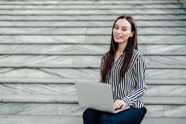 Femme travaillant sur un ordinateur portable à l'extérieur