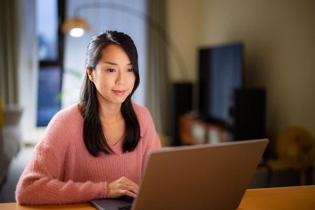 Femme travaillant sur un ordinateur portable à la maison le soir