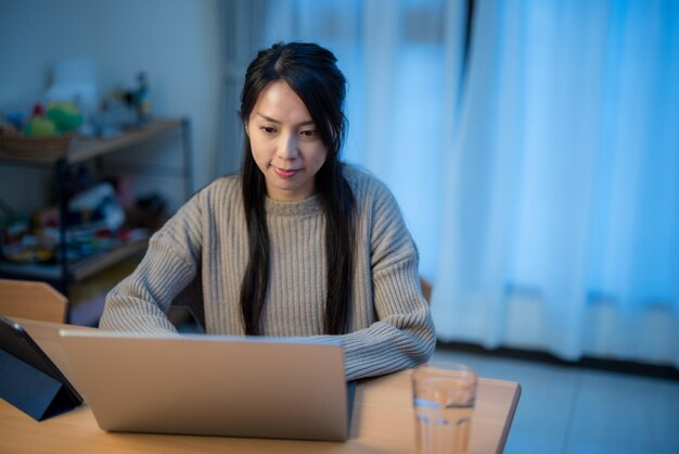 Photo femme travaillant à l'ordinateur portable à la maison