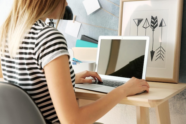 Femme travaillant sur ordinateur portable à la maison