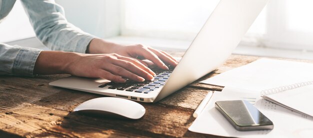 Femme travaillant sur un ordinateur portable et un tablet pc à l'intérieur