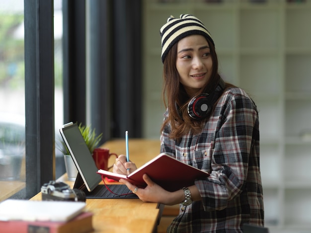 Femme travaillant sur sa mission tout en écrivant sur un ordinateur portable dans un espace de travail confortable