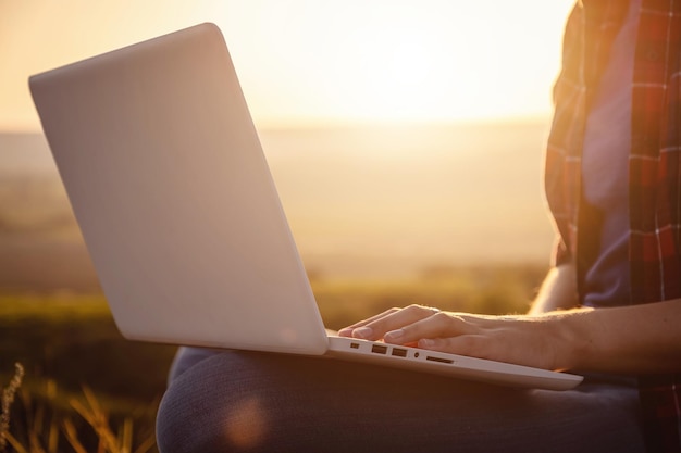 Femme travaillant sur son ordinateur au sommet de la montagne