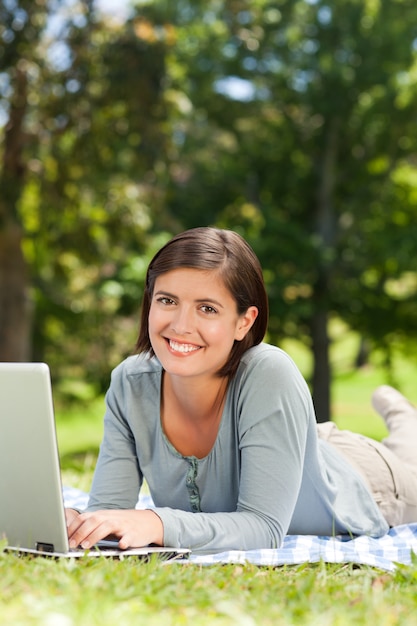 Femme travaillant sur son ordinateur portable dans le parc