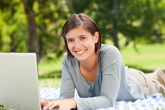 Femme travaillant sur son ordinateur portable dans le parc