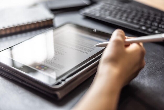 Photo femme travaillant avec une tablette numérique et un stylo vérifiant le contrat ou l'accord de document gros plan