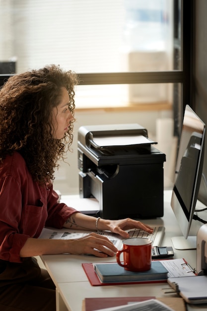 Photo femme travaillant avec la vue de côté d'ordinateur