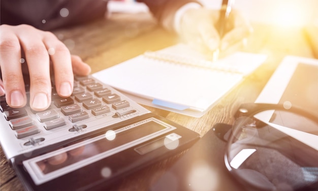 La femme travaille sur une calculatrice