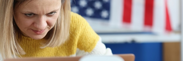 Photo femme travaille sur ordinateur en arrière-plan accroché un drapeau américain en remplissant un questionnaire sur