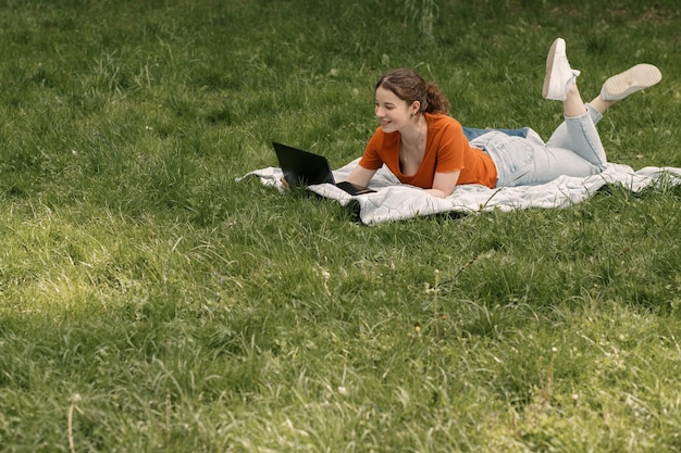 Femme travaille avec un ordinateur portable dans le parc