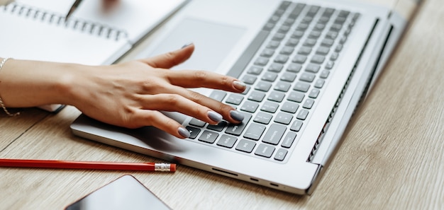 Femme travaille sur un ordinateur portable sur le lieu de travail