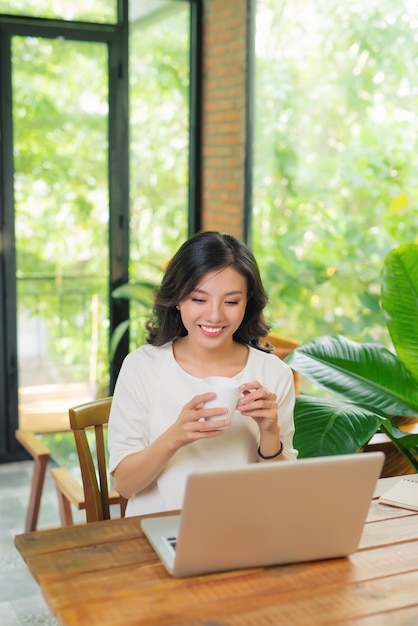 La femme travaille sur le PC au café d'Internet