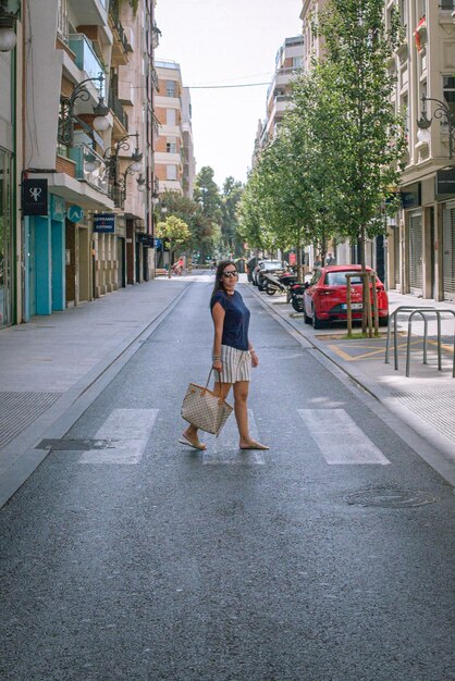 Une femme traversant la rue en ville.