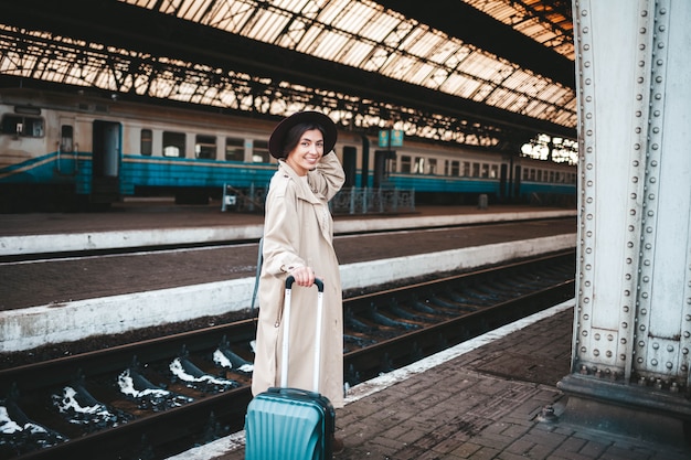 Femme très souriante à la gare.