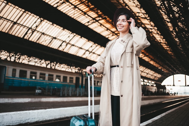 Femme très souriante à la gare.