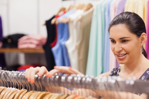 Femme triant des vêtements sur le rail