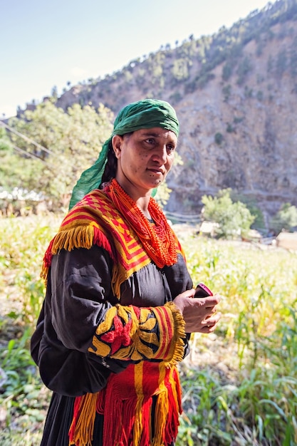 Femme de la tribu Kalash vêtue de façon traditionnelle souriant dans le village de la vallée de Kalash au Pakistan