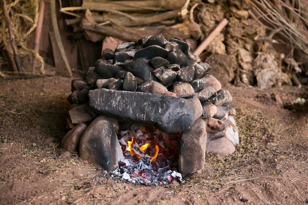 Femme d'une tribu Quechua préparant un four en pierre pour la cérémonie Pachamanca à Maras, Cusco, Pérou.