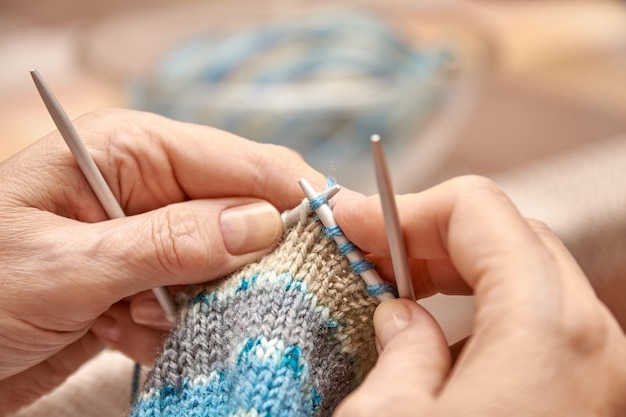 Femme tricote des chaussettes. Un passe-temps de femme âgée est le tricot. Vue rapprochée de la boucle de tricot. Mise au point sélective