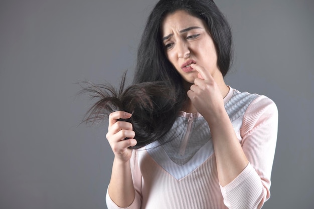 Femme triste cheveux abîmés à la main