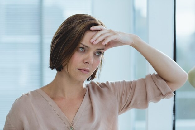 Femme triste, debout, chez soi