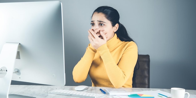 Femme triste avec ordinateur et graphique au bureau