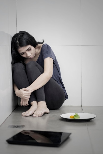 Femme triste avec salade et balances de poids