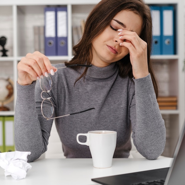 Photo femme à la triste tout en travaillant à domicile