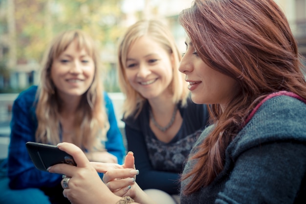 femme de trois amis à la barre en utilisant le téléphone