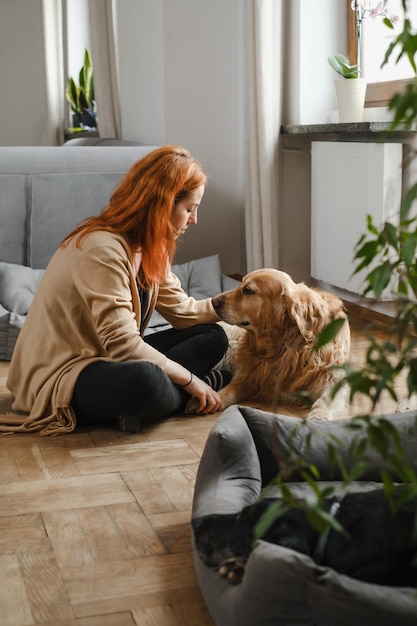 Femme avec trois chiens câlins sur le sol