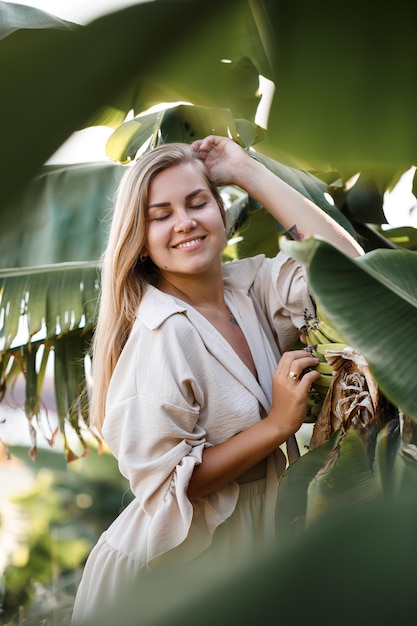 Femme tropicale exotique près des feuilles vertes du bananier. Fille de l'île tropicale en vacances