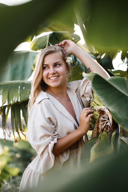 Femme tropicale exotique près des feuilles vertes du bananier. Fille de l'île tropicale en vacances