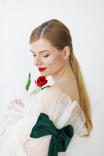 Femme avec une tulipe rouge