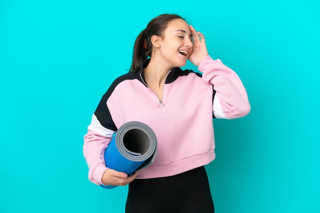 Femme ukrainienne sportive allant à des cours de yoga tout en tenant un tapis en souriant beaucoup