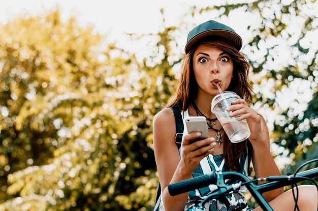 Femme urbaine assise sur le vélo faisant la grimace.