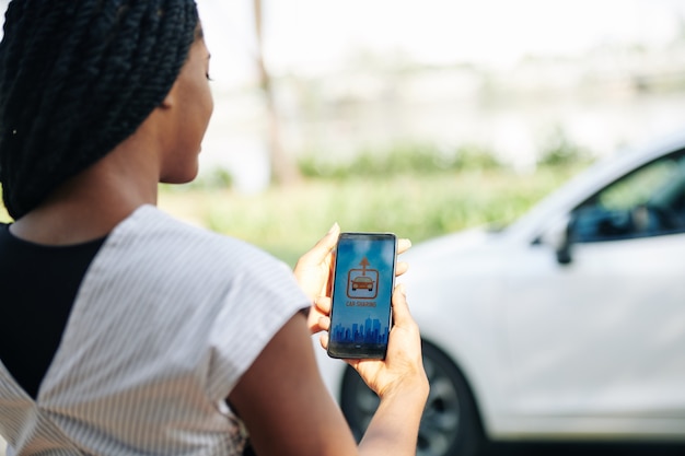 Femme utilisant l'application de partage de voiture