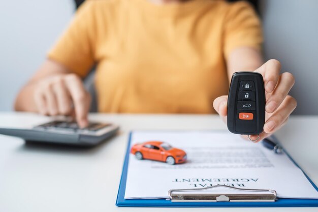 Femme utilisant une calculatrice lors de la signature du document contractuel acheter et vendre des concepts d'accord de location et de contrat d'assurance