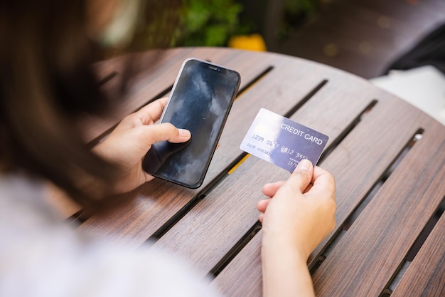 Femme utilisant une carte de crédit et un smartphone pendant l'écran de diapositives pour trouver un produit