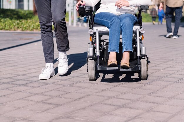 Femme utilisant un fauteuil roulant avec un homme se promenant