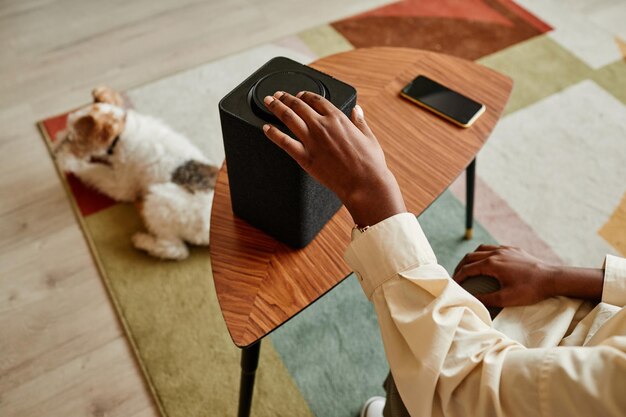 Femme utilisant un haut-parleur intelligent dans une maison moderne