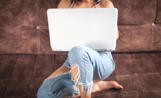 Femme utilisant un ordinateur portable blanc à la maison