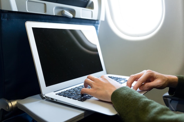 Femme utilisant un ordinateur portable dans un avion