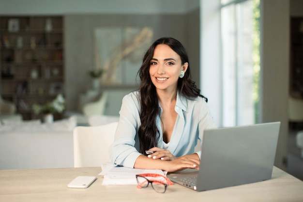 Femme utilisant un ordinateur portable à l'intérieur du bureau à domicile