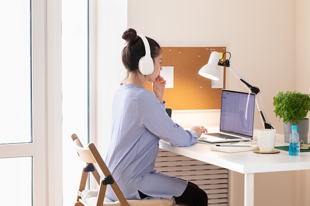 Photo femme utilisant un ordinateur portable, lieu de travail dans un style moderne. communication et télétravail. distance sociale