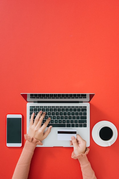 Femme utilisant un ordinateur portable moderne à la table des couleurs, vue de dessus