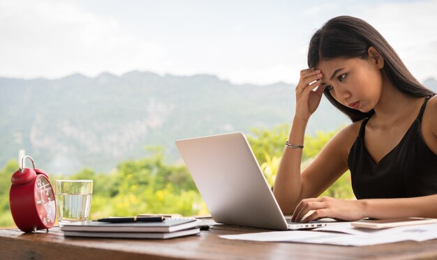 Femme utilisant un ordinateur portable tout en se souciant de son travail. Tard en retard pour la date limite.