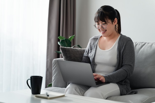 Femme utilisant un ordinateur portable travaillant au bureau à domicile ou sur le lieu de travailxA