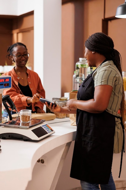 Photo femme utilisant le paiement sans espèces au marché